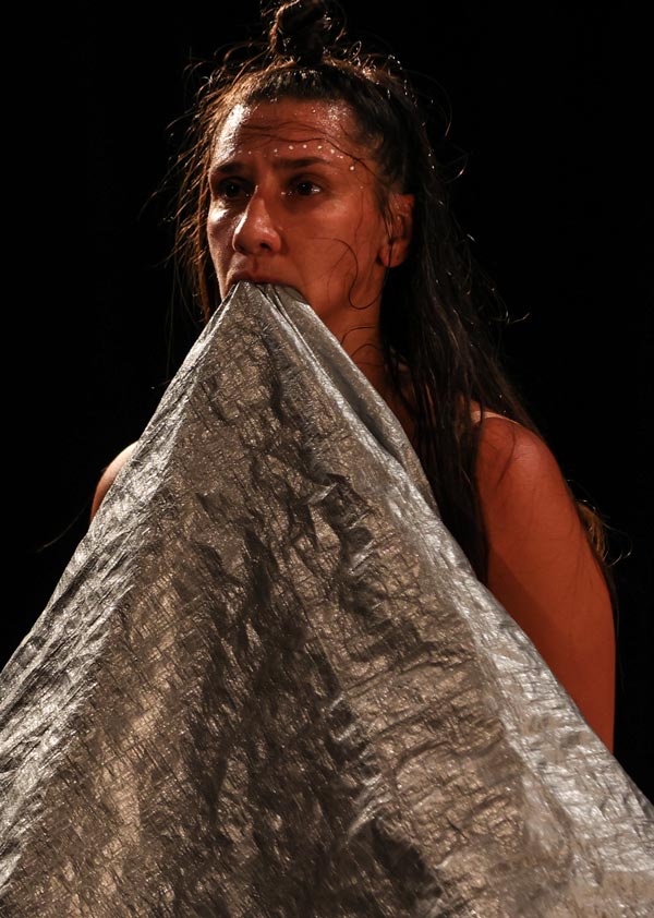 image of Jeanette holding a silver tarp in her mouth