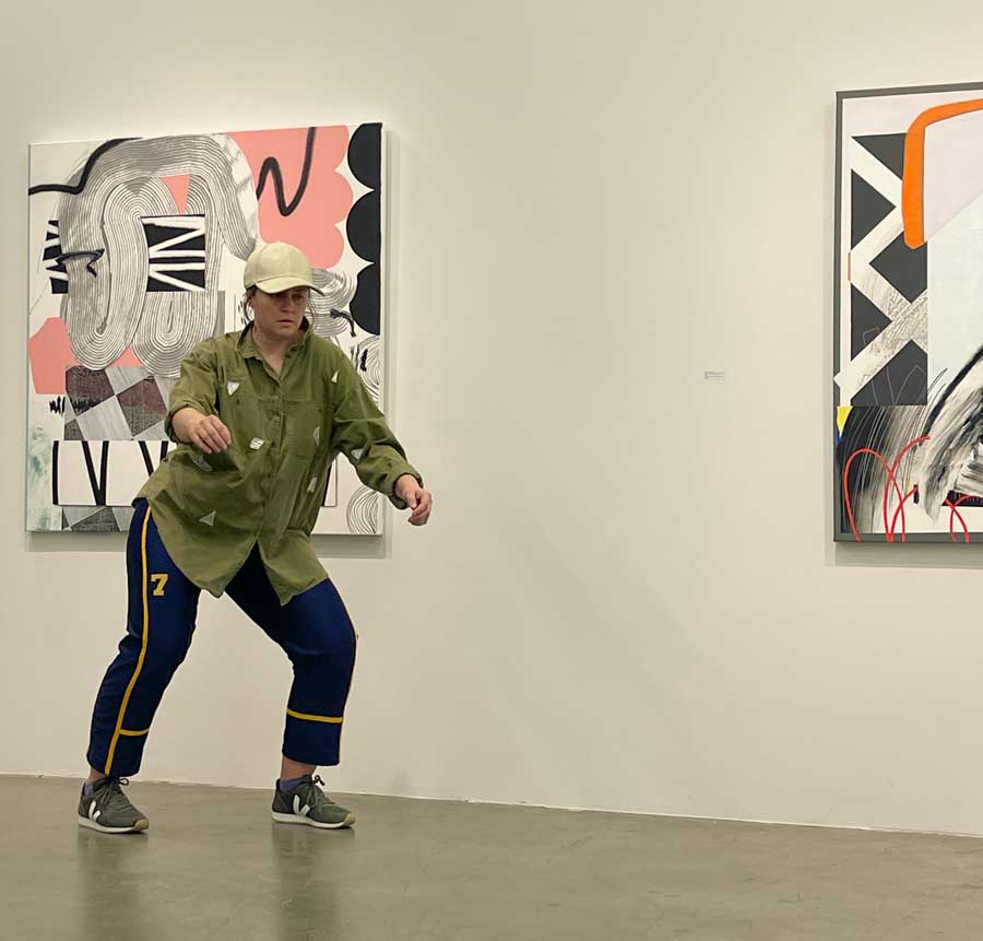 me, DP dancing in a gallery in front of two paintings; photo Jeanette Kotowich