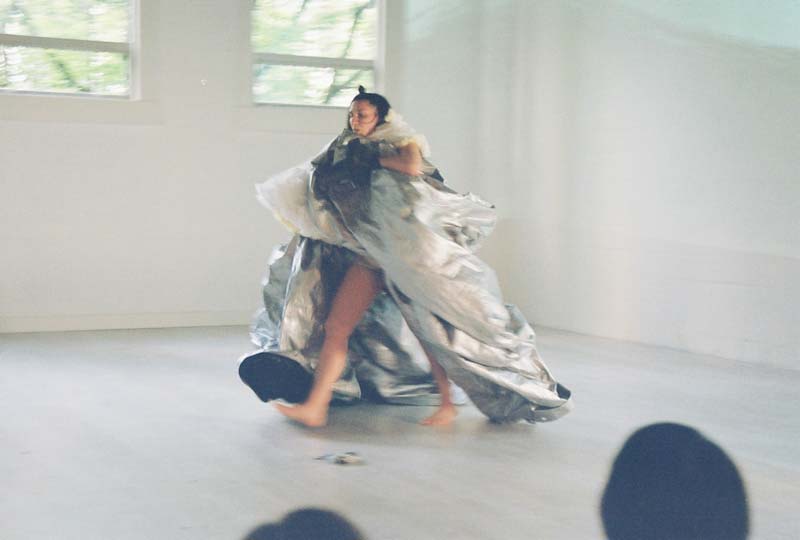image of Jeanette walking while carrying a large silver tarp