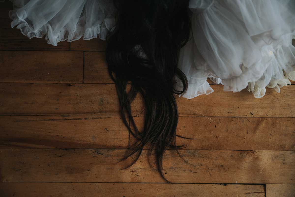 an image of black hair and white crinoline on a wood floor